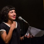 Melissa Lozada-Oliva takes a moment between poems during her feature set. Photo by Rich Beaubien.